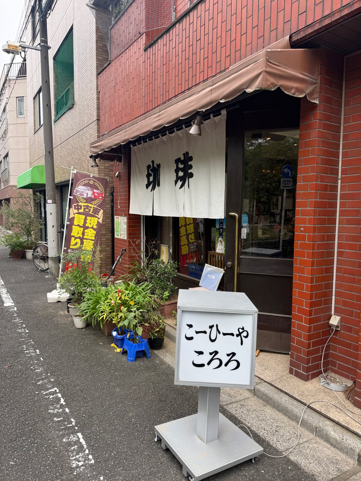 「こーひーや ころろ」の看板と珈琲の暖簾が下がる路地の店