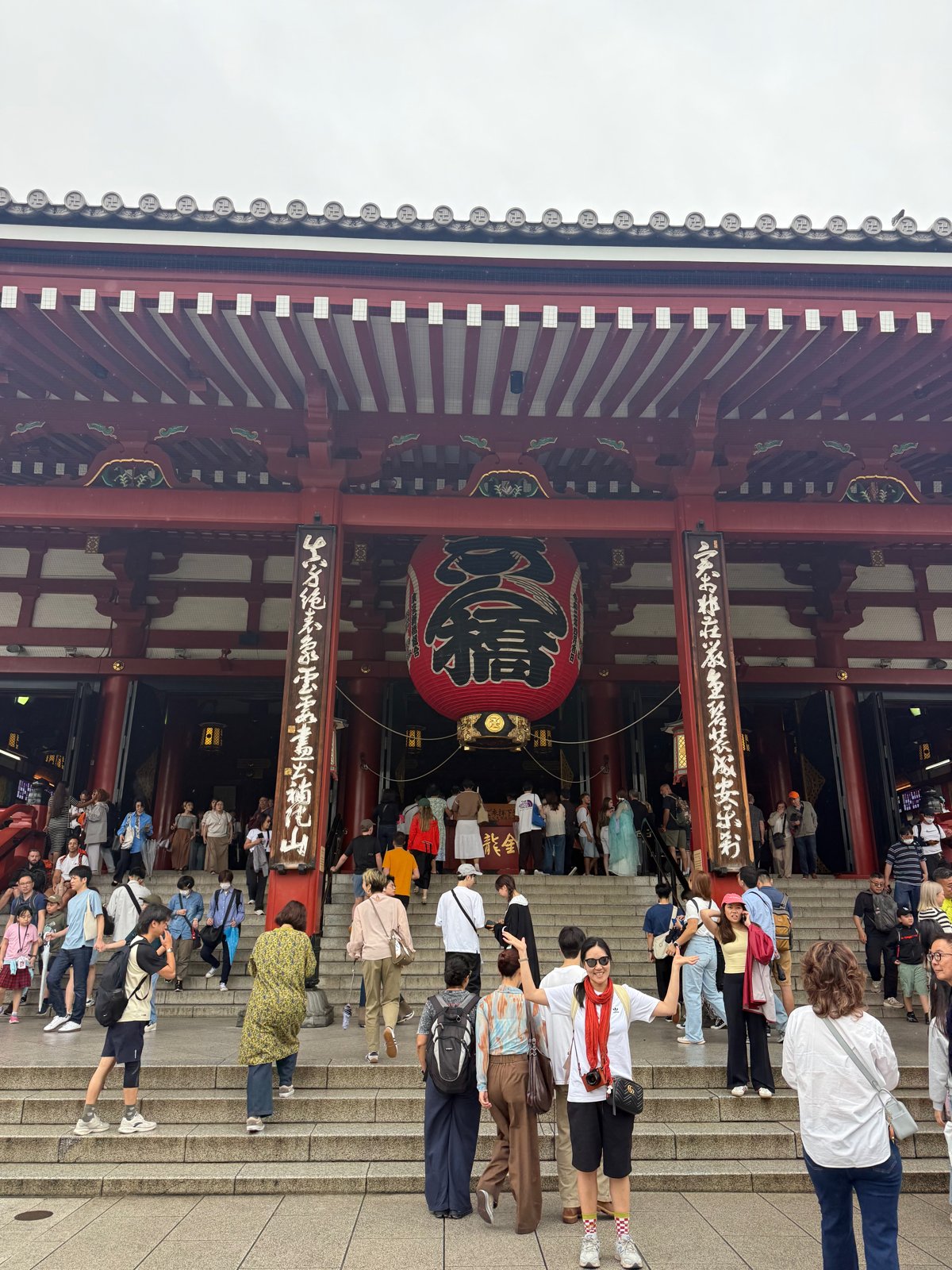 大きな赤い提灯が下がる浅草寺の門と、石段を上る大勢の人