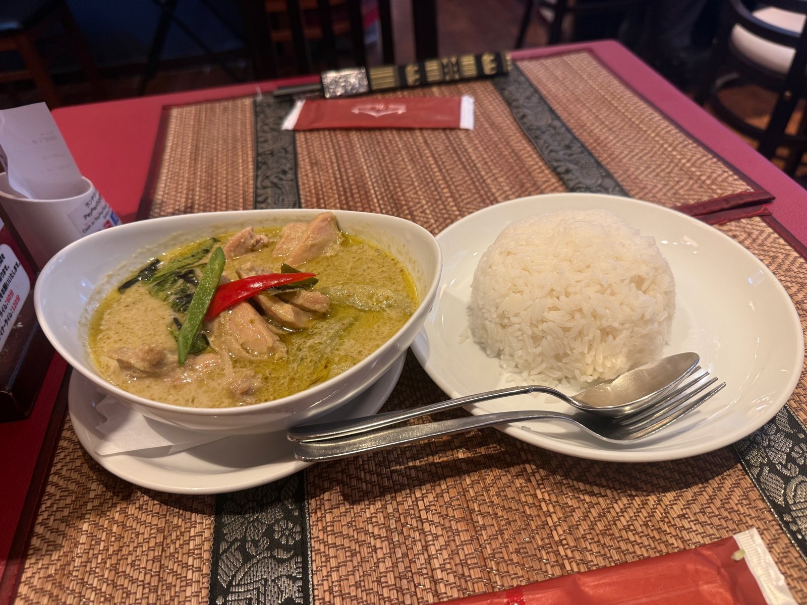 鶏肉と赤唐辛子が入ったグリーンカレーと、白いごはんの皿