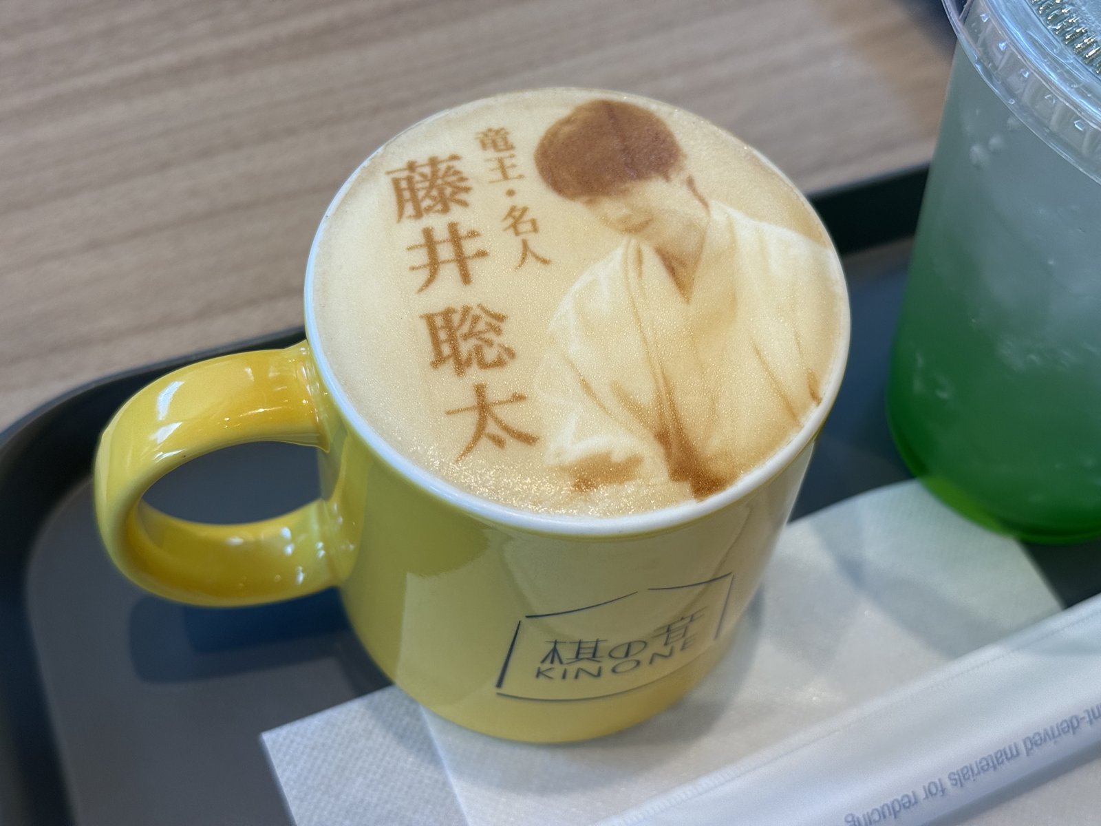 藤井聡太の肖像が描かれた、黄色いマグカップのカフェオレ